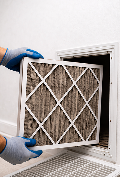Clogged home air filter pulled out of return vent by technician